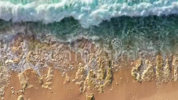 沙滩上白色泡沫的平静波浪翻滚视频的预览图