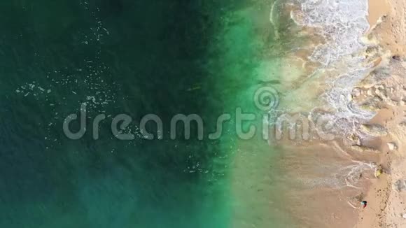 青绿色的海浪在干净的沙滩上缓缓地翻滚视频的预览图