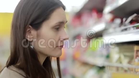 女孩选择商店货架上的商品视频的预览图