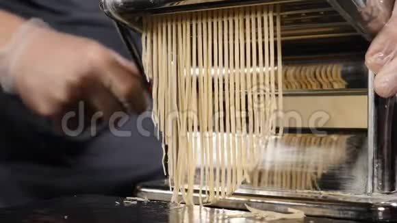 传统的意大利自制面食正在手工机上制作用于切割面团新鲜食物的慢镜头视频的预览图
