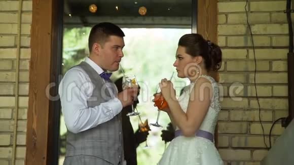 新娘和新郎手持五颜六色的鸡尾酒视频的预览图