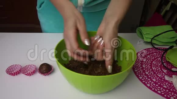 一个女人用她的手从一个由饼干和可可面包屑制成的团里滚球加上黄油做空白视频的预览图
