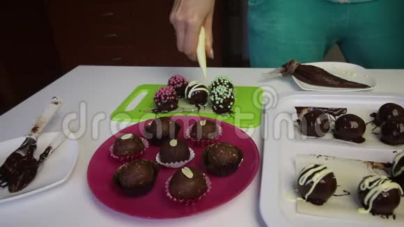 女人用巧克力装饰巧克力海绵球做土豆蛋糕盘子旁边是蛋糕液体视频的预览图
