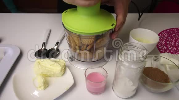 饼干倒入搅拌机碗中一个人连接一个设备把饼干碎在碗里其他制作原料视频的预览图