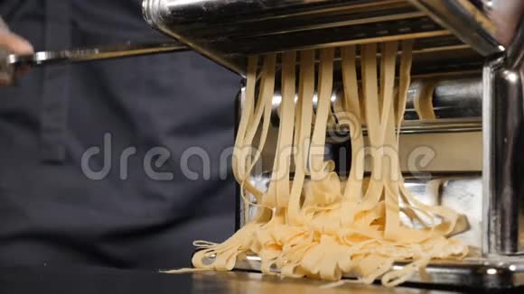 传统的意大利自制面食正在手工机上制作用于切割面团新鲜食物的慢镜头视频的预览图