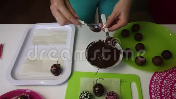 一个女人把一个巧克力海绵球放在表面装饰用洒水做一个土豆蛋糕盘子旁边是蛋糕视频的预览图
