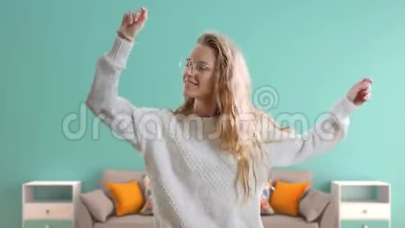 快乐的年轻女子在听音乐跳舞微笑在家戴眼镜的积极少年女孩视频的预览图