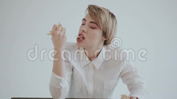 这位女士有一份炸薯条和一个汉堡包学生的肖像那个女孩正试图吃垃圾宣传快餐视频的预览图