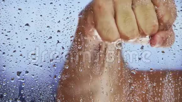 一场雨过后一只手按在湿漉漉的窗户上特写镜头视频的预览图