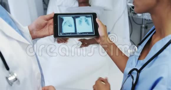 多民族医生的特写讨论医院病房数字化平板电脑的x光报告视频的预览图