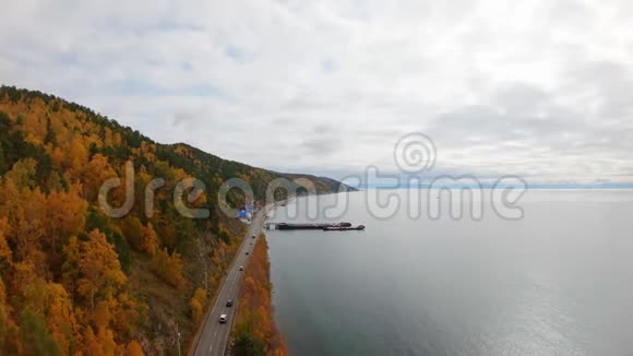 在贝加尔的Listvyanka村沿海岸公路行驶的汽车的鸟瞰图视频的预览图