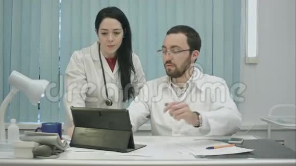 男性和女性医生讨论使用结果视频的预览图