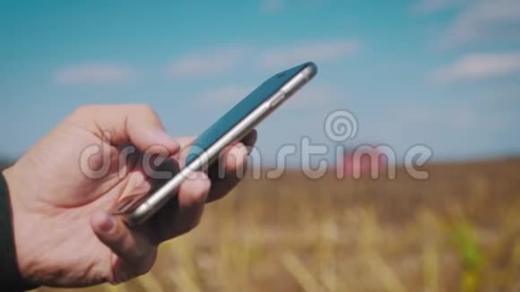 智慧农业技术男人在农场使用智能手机用技术预测未来视频的预览图