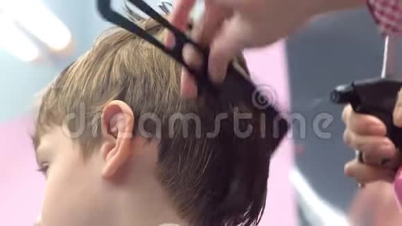 理发师用梳子梳头发然后用水喷洒后景造型师双手特写视频的预览图