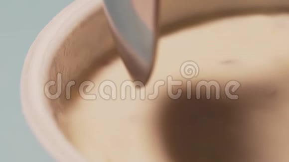 勺子慢慢浸入酸奶中宏拍在白色背景上用勺子吃素食乳制品视频的预览图