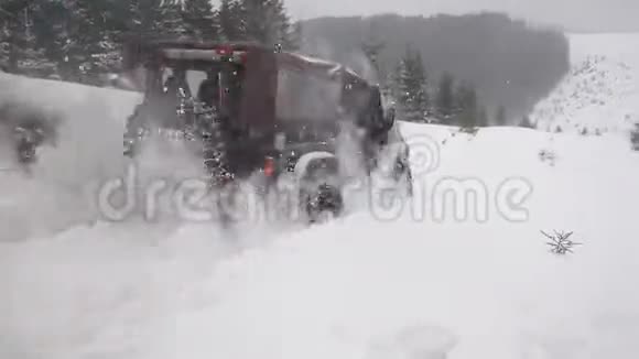 烟雾缭绕的越野车在深山的大雪中行驶视频的预览图