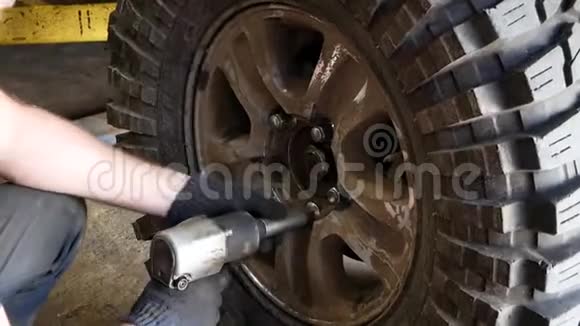 机械师用扳手拧开一辆SUV的脏轮视频的预览图