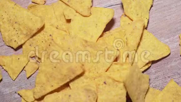 玉米片落在木板上特写有害的墨西哥小吃不健康的快餐脆的咸的黄玉米三角形视频的预览图