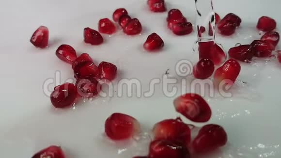 水在白色的表面流淌着多汁的红石榴粒视频的预览图