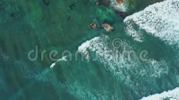 巨大的灰色岩石包围着无边的海浪视频的预览图