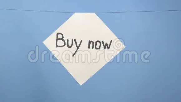 燃烧和吸烟的白纸上有黑色的铭文现在购买蓝色背景视频的预览图