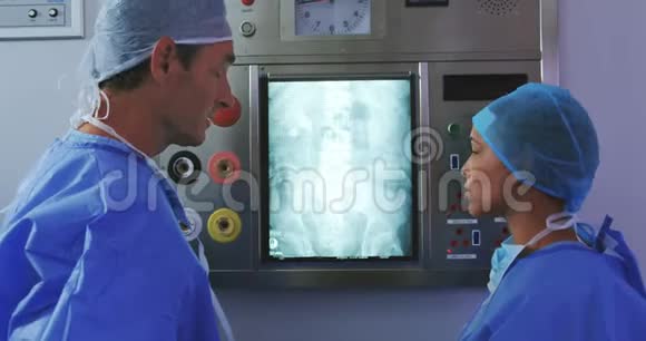 多民族医生对医院灯箱x光报告讨论的侧视视频的预览图