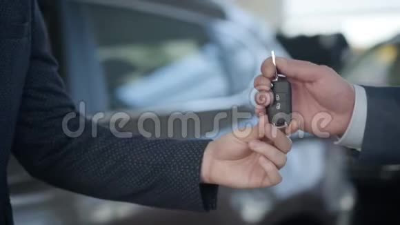 一群穿着商务服的面目全非的白种人男人通过汽车钥匙和握手商人买新的视频的预览图