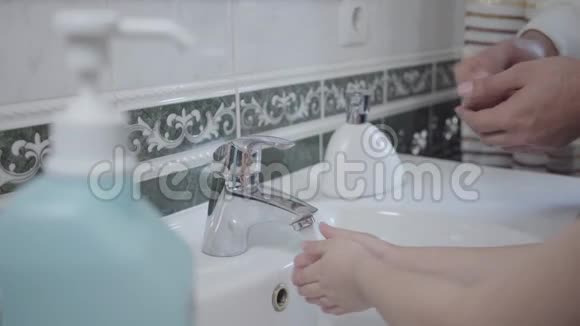 无法辨认的男人和小女孩在浴室里用肥皂和水洗手父女做卫生工作视频的预览图