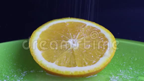一片圆圆的橘子看起来非常多汁开胃地撒上糖在刚切好的切片上加糖视频的预览图