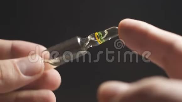 慢动作玻璃安瓿在一个人的手黑色的背景药丸治理念近点视频的预览图