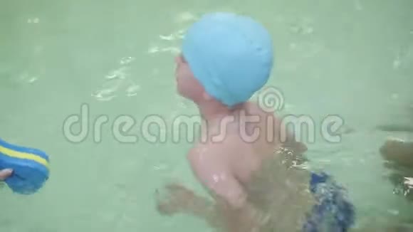 这个男孩学会在游泳池里游泳6岁的男孩在幼儿园的室内游泳池游泳视频的预览图