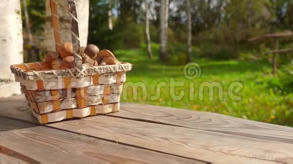 一个篮子上面放着新鲜采摘的蘑菇落在户外的木制表面上视频的预览图