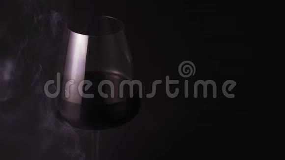 酒精和烟雾被隔离在黑色背景下特写一杯特别漂亮的红酒视频的预览图