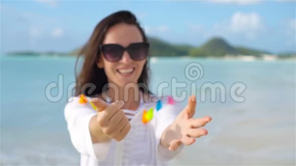 跟着我波夫快乐的女孩看着相机在海滩上微笑视频的预览图