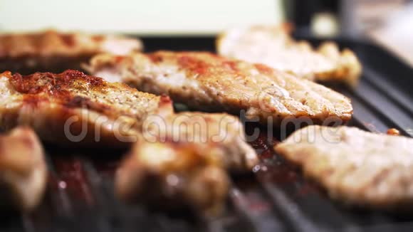 特写镜头在电烤架上煮肉猪肉用自己的果汁煎慢动作视频的预览图