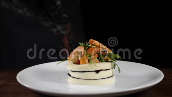豪华餐厅街头美食精品美食用新鲜蔬菜沙拉在白色盘子上倒入香料慢动作视频的预览图