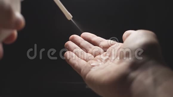 慢动作特写一个男人手中溅起的消毒剂在手掌上揉搓防止了手的扩散视频的预览图