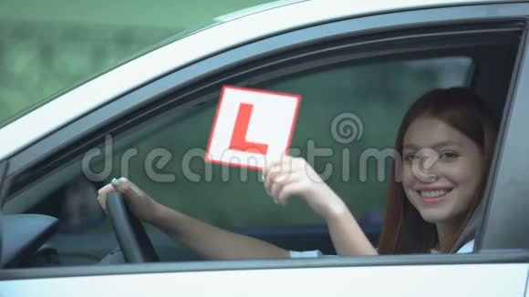 坐在驾驶座上的女孩在车上展示l板在教学中学习视频的预览图