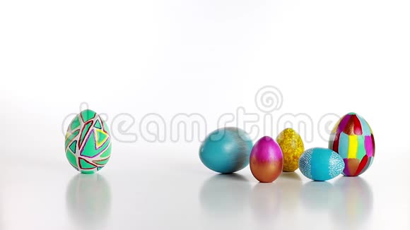 木勺把彩蛋推到一群复活节彩蛋上鸡蛋互相碰撞在白色背景上滚动视频的预览图
