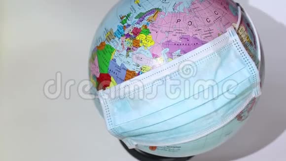 地球仪戴着医疗面罩地球仪上戴着医用面罩世界检疫冠状病毒大流行视频的预览图