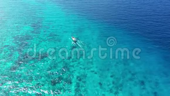 孤独的摩托船航行在无边的蓝色透明的海洋上视频的预览图