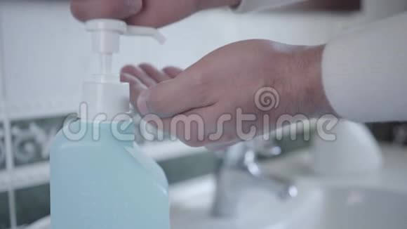 男士用洗手液消毒双手的特写冠状病毒期间男性手掌涂抹液体视频的预览图
