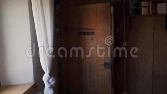 穿着波尔卡多礼服的可爱女孩打开旧木门进入房间视频的预览图