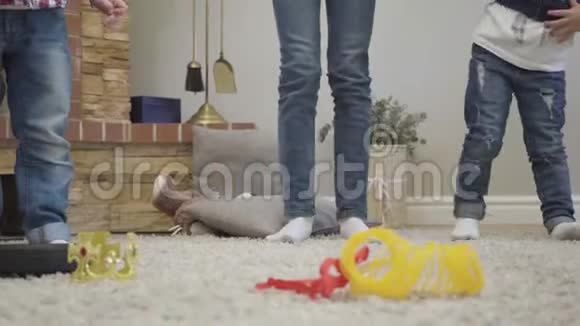 三个不同年龄的孩子穿着休闲牛仔裤跳跃的腿兄弟姐妹在家玩得开心视频的预览图