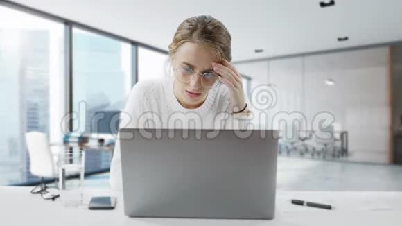 年轻漂亮的女商人在办公室工作累了无聊的年轻女人正在用笔记本电脑工作盯着看视频的预览图