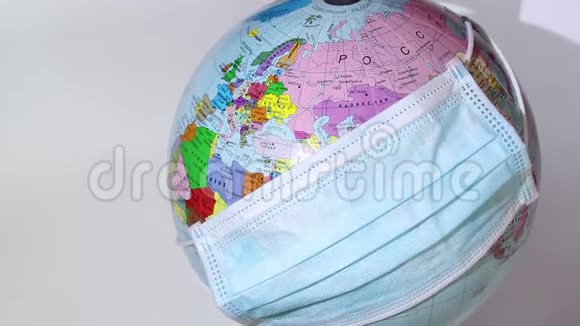 地球仪戴着医疗面罩地球仪上戴着医用面罩世界检疫冠状病毒大流行视频的预览图