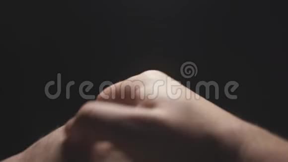 特写一个男人手放在黑色的背景上一个男人手在手掌上喷洒消毒剂摩擦预防视频的预览图