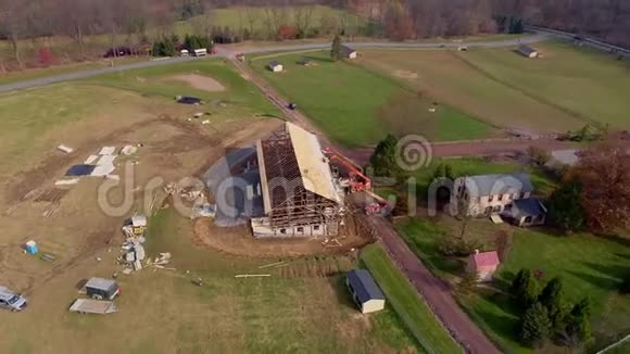 一架无人驾驶飞机仔细修复的木架谷仓空中盘旋的景象视频的预览图