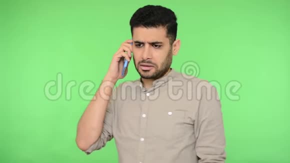 年轻的黑发男子穿着衬衫在手机上交谈给出解释隔离在绿色背景上色度键视频的预览图