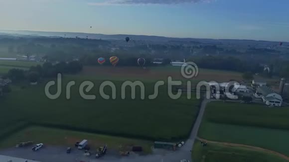 在阿米什农场的一个节日期间多个热气球降落的空中景观视频的预览图